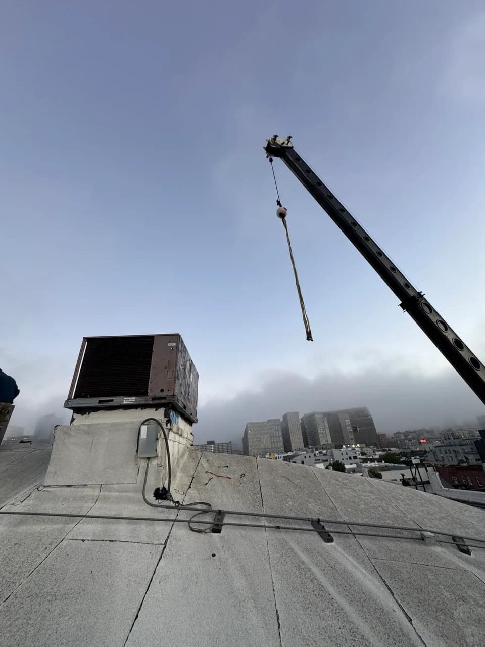 Replacement HVAC unit craned into place on a commercial building