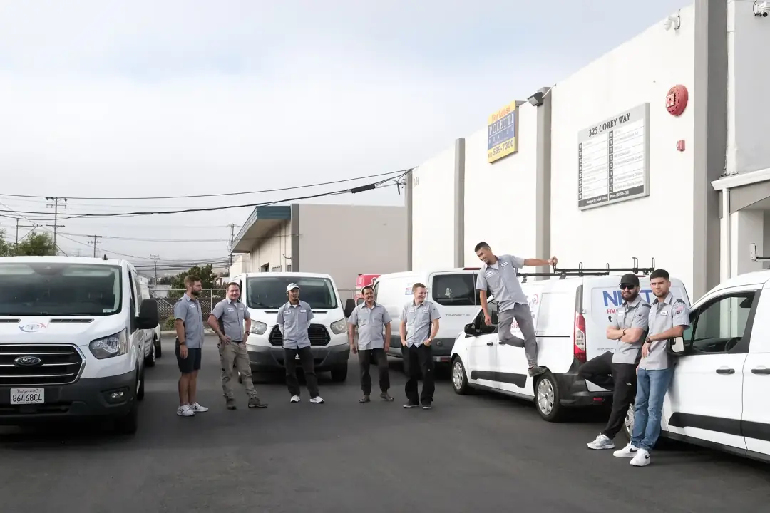 Next HVAC technicians standing with the service van fleet outside the South San Francisco shop
