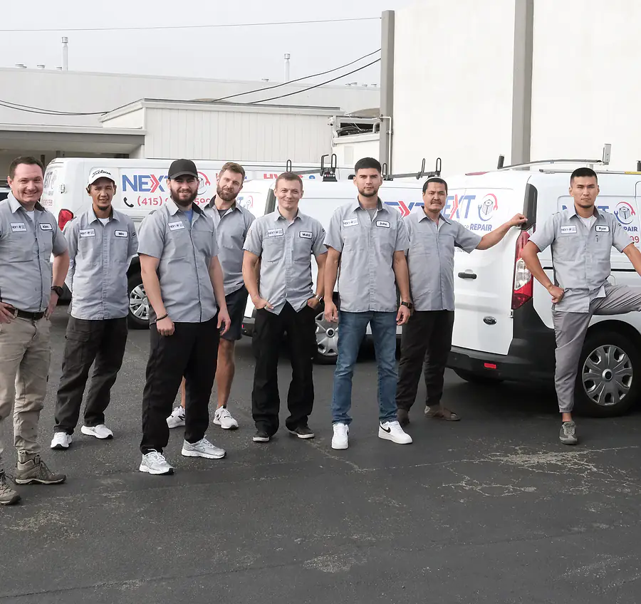 The Next HVAC & Appliance Repair crew in grey uniforms lined up in front of the company vans